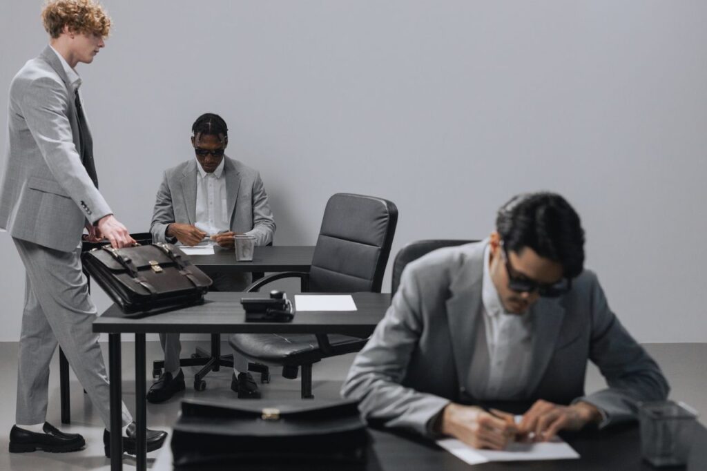 Business office with diverse employees in gray suits working at desks in an indoor setting.